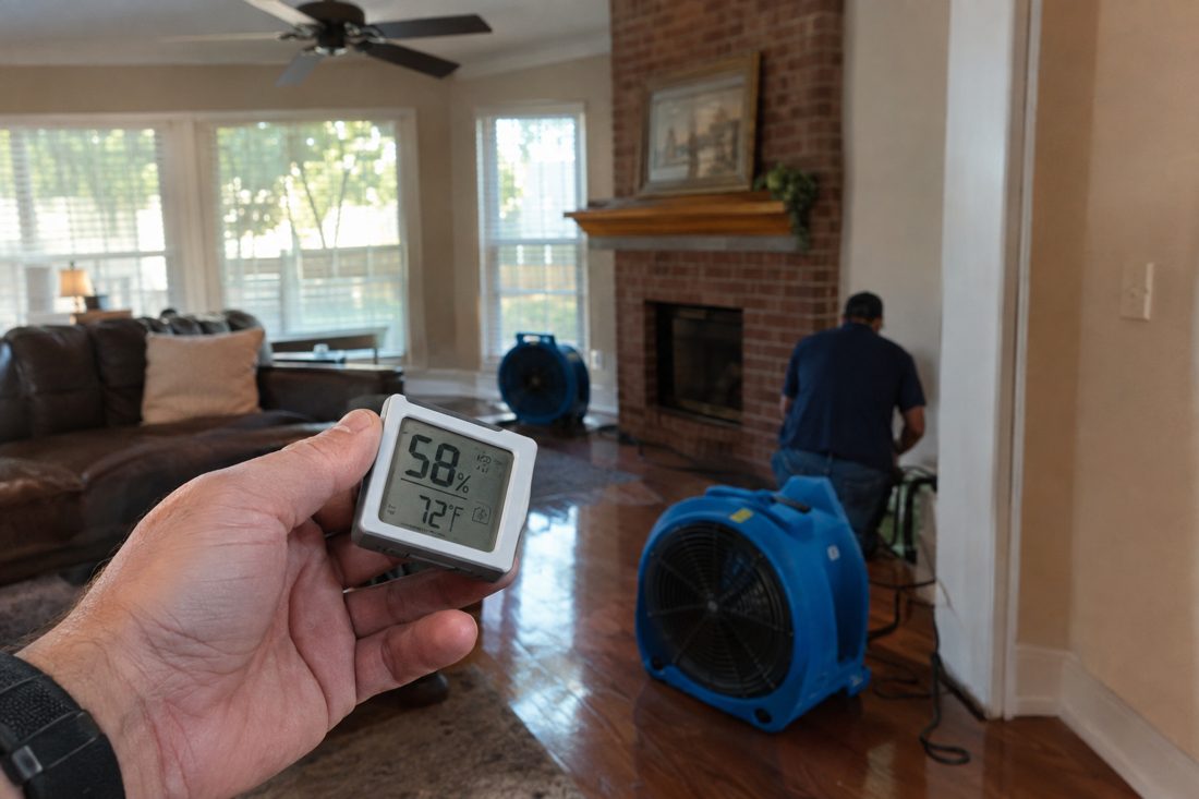 A close-up of a hygrometer reading humidity in a room with fans running at a brick two-story suburban house in North Texas near Lake Ray Hubbard in Rowlett, TX